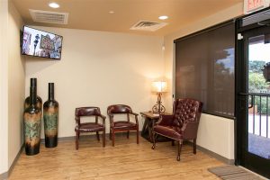 Bellaire Dental Excellence front office with chairs, doorway, tv and decorations